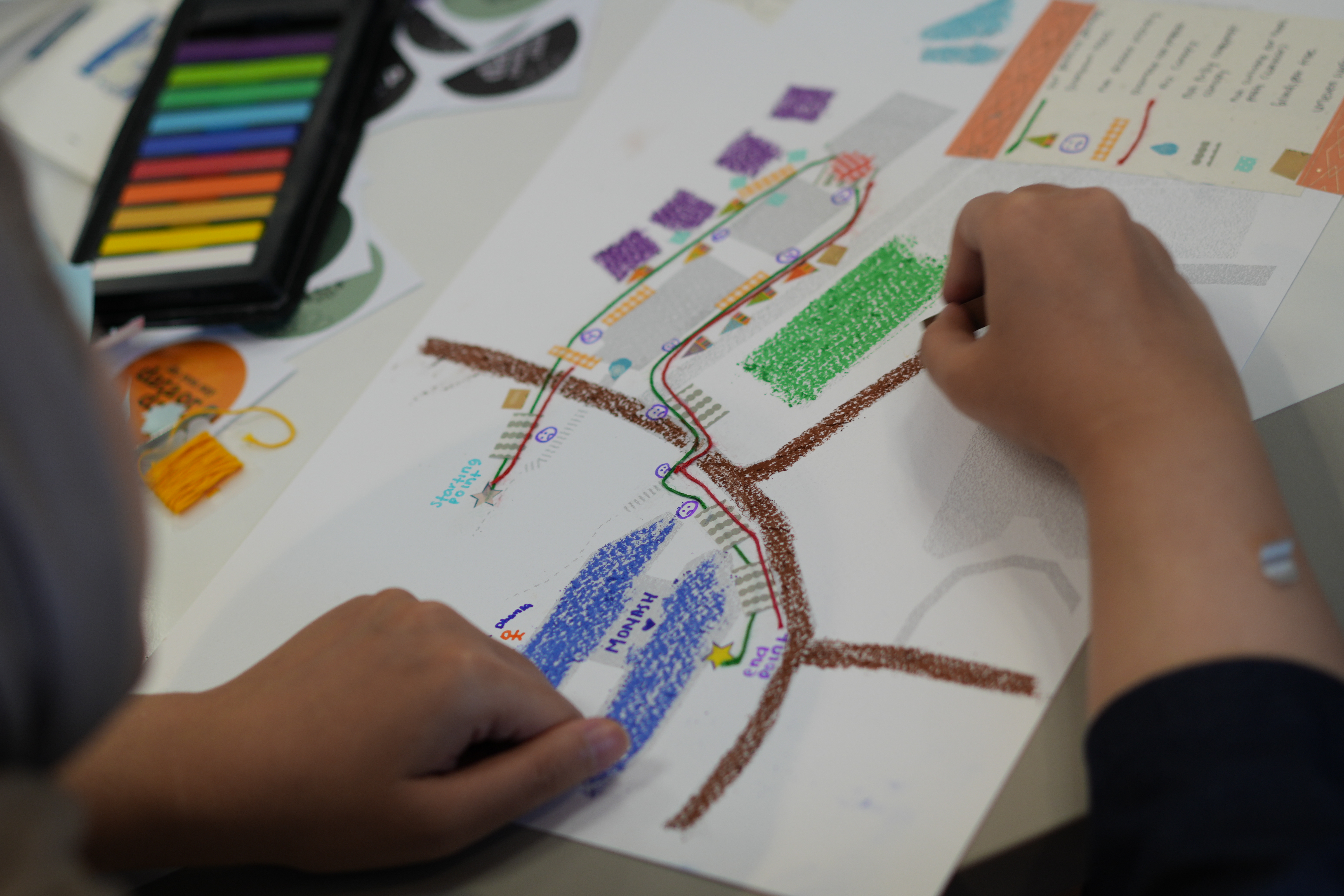Figure 4. A student using colourful pastels to create a hand-drawn map. Credit: Monash University Indonesia.